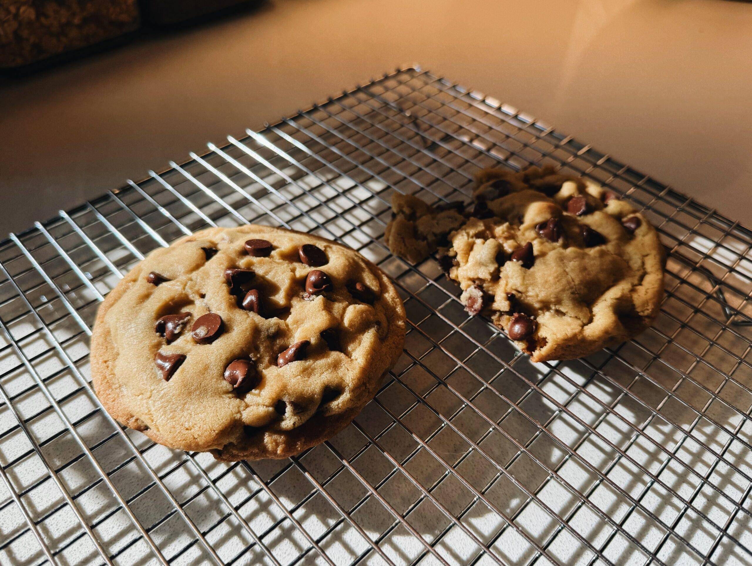 Two cookies on a cooling rack.