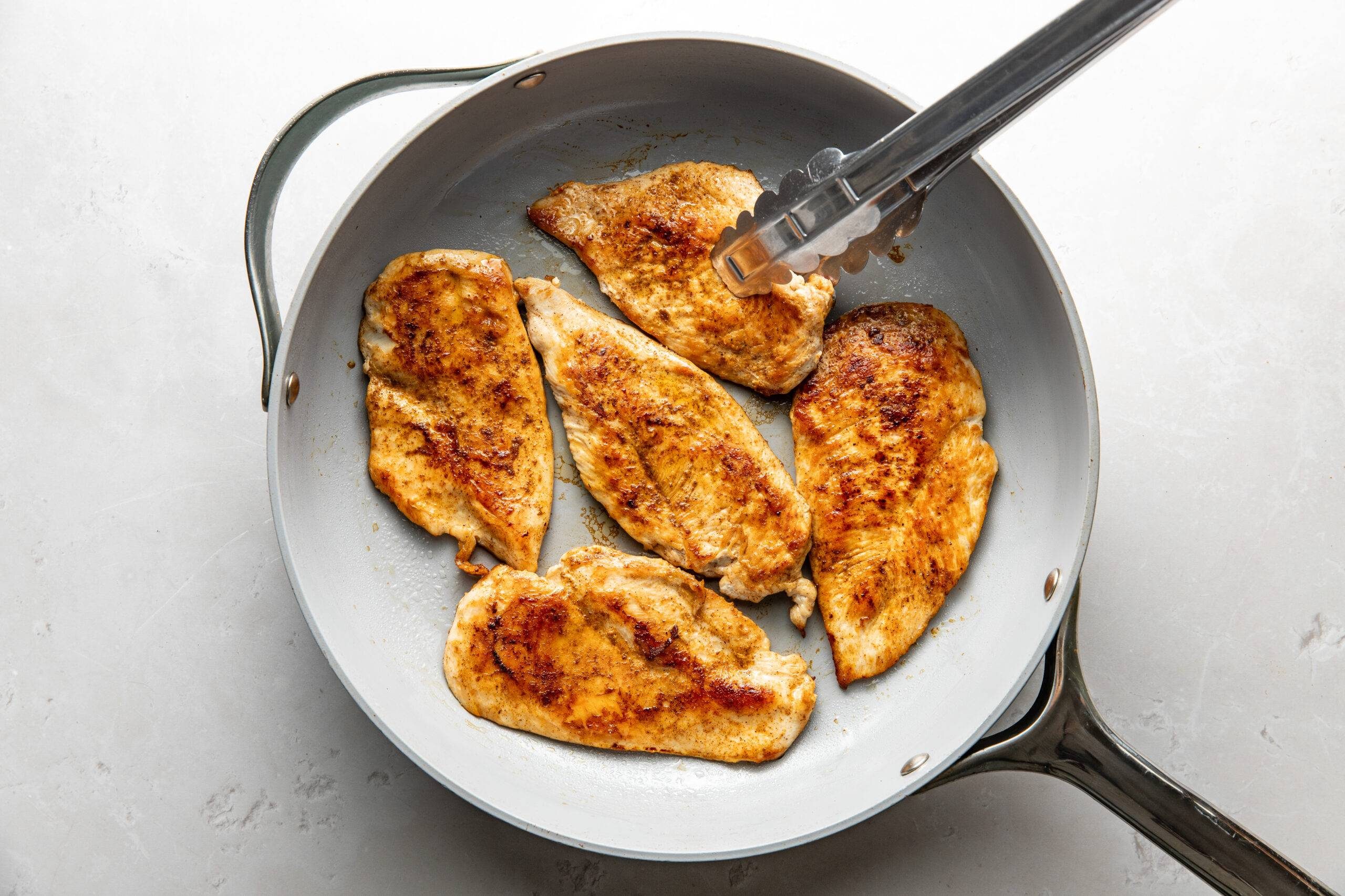 Cooking chicken in a skillet.