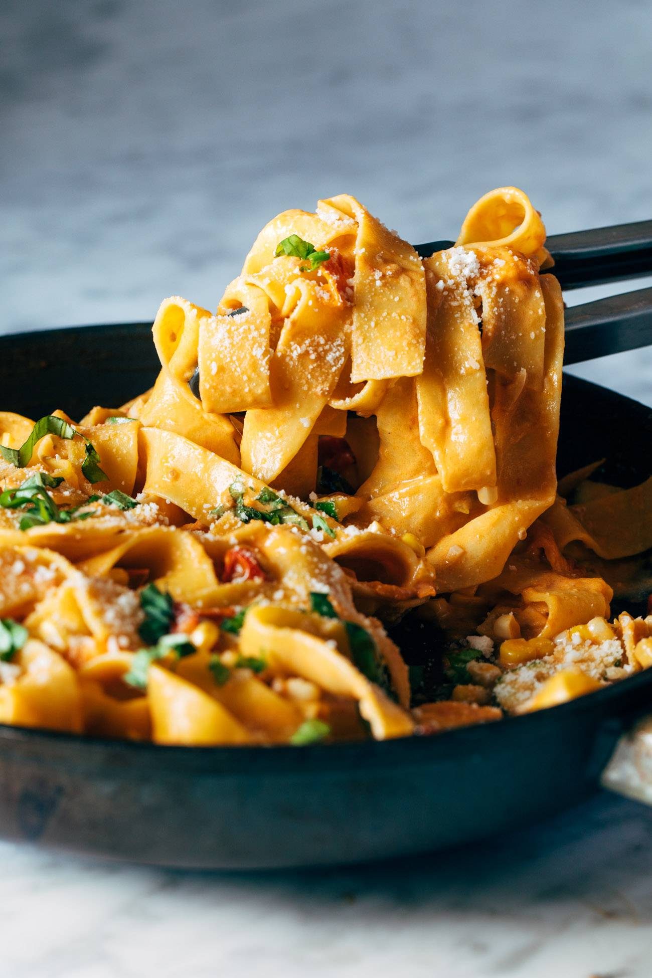 Chopsticks grabbing noodles for Burst Tomato Pappardelle. 