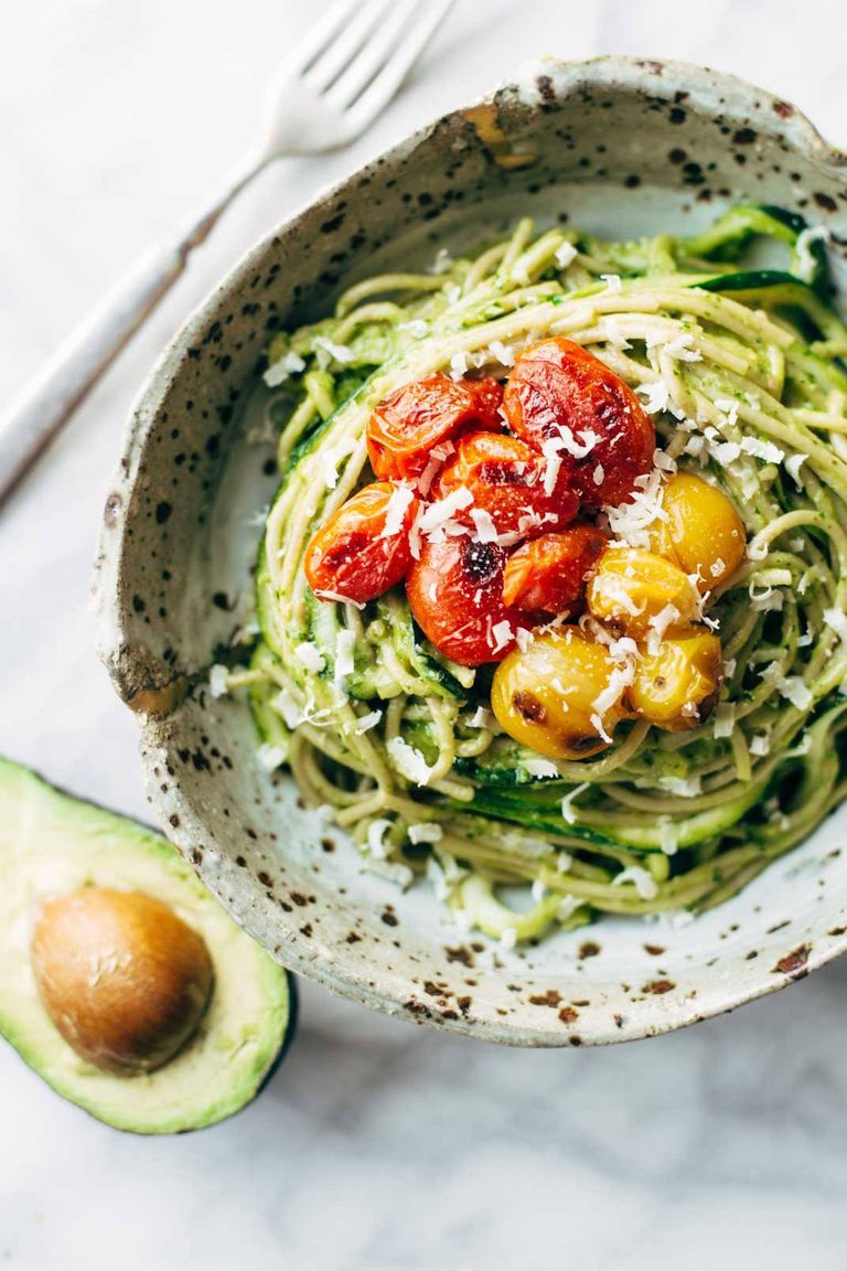 Zucchini noodles and spaghetti with roasted tomatoes on top.