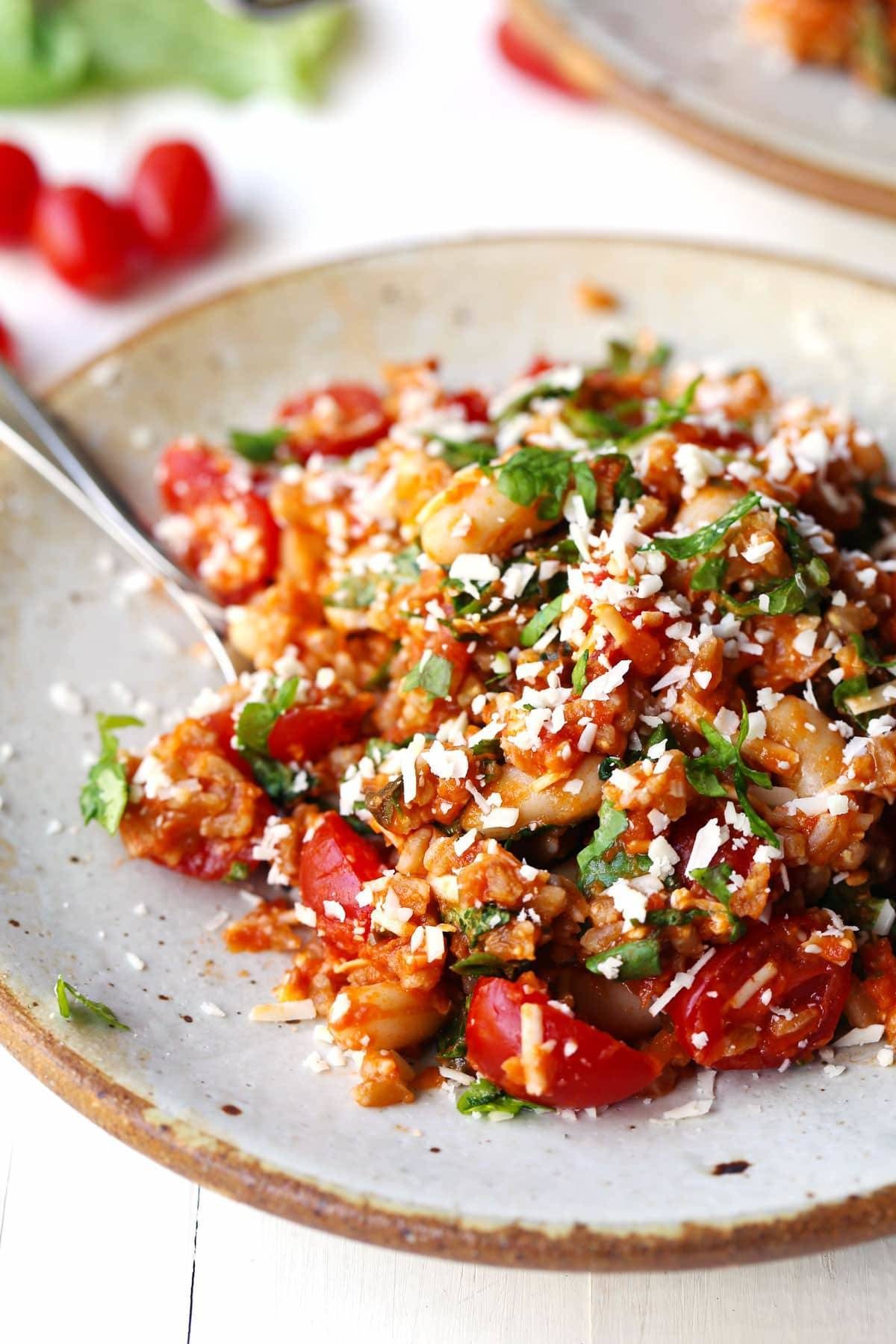 Asiago White Beans with Farro, Kale, and Tomatoes on a plate.