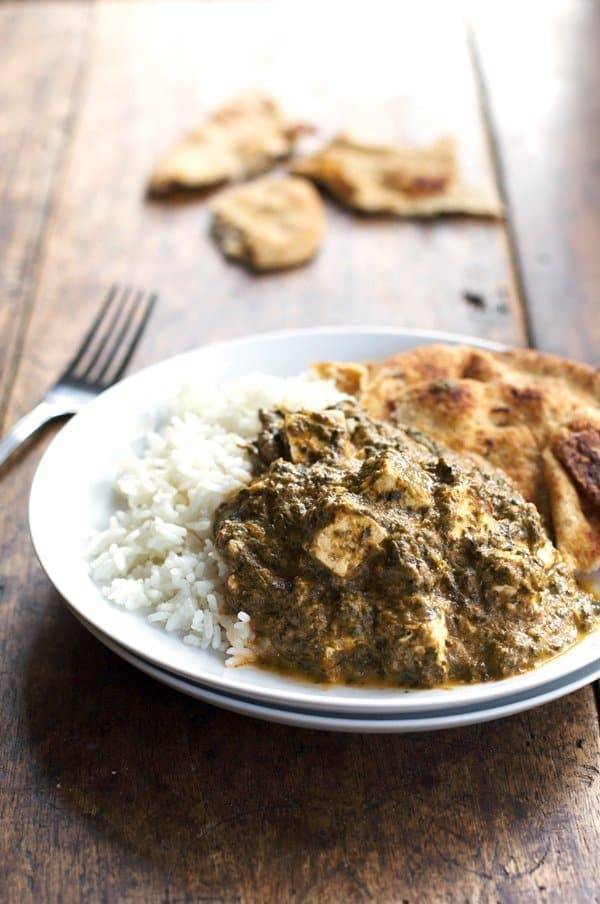 Palak paneer with rice on a plate.