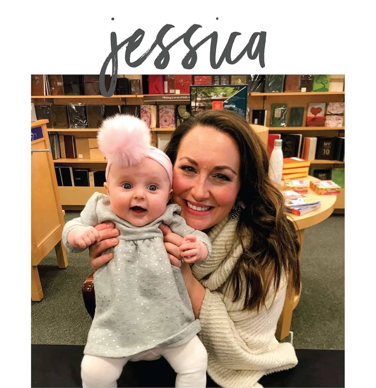 A smiling woman holds a baby girl.