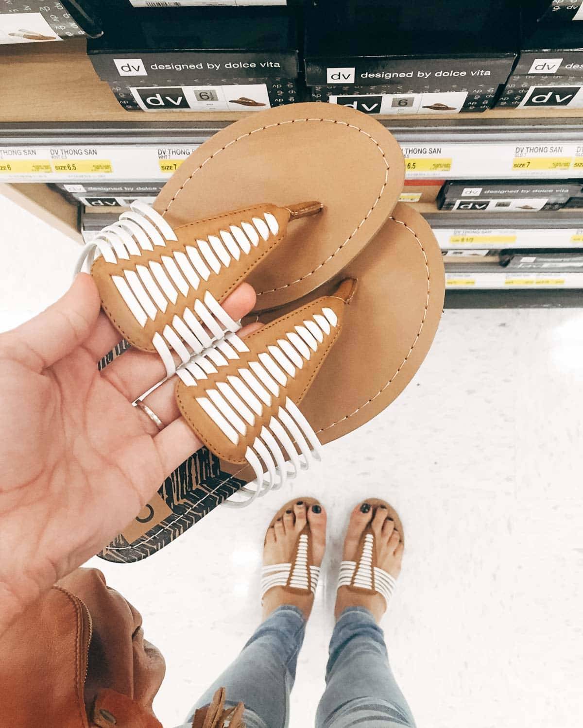 Hand holding a pair of sandals.