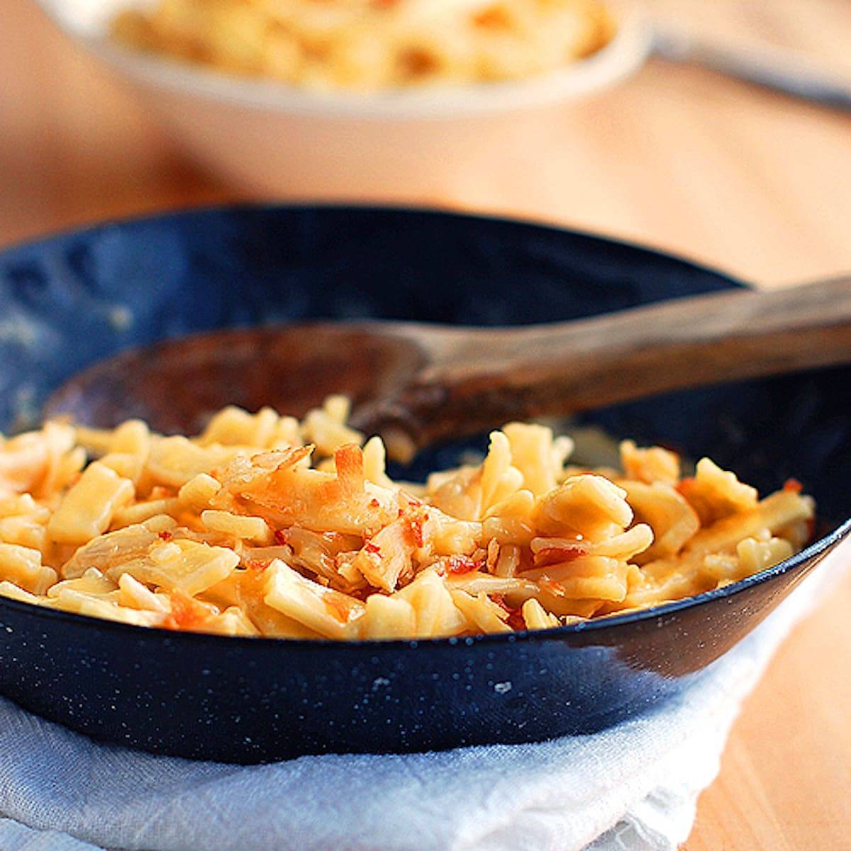 Cheesy chicken noodles coated in a creamy sauce and tossed with shredded chicken in a skillet.