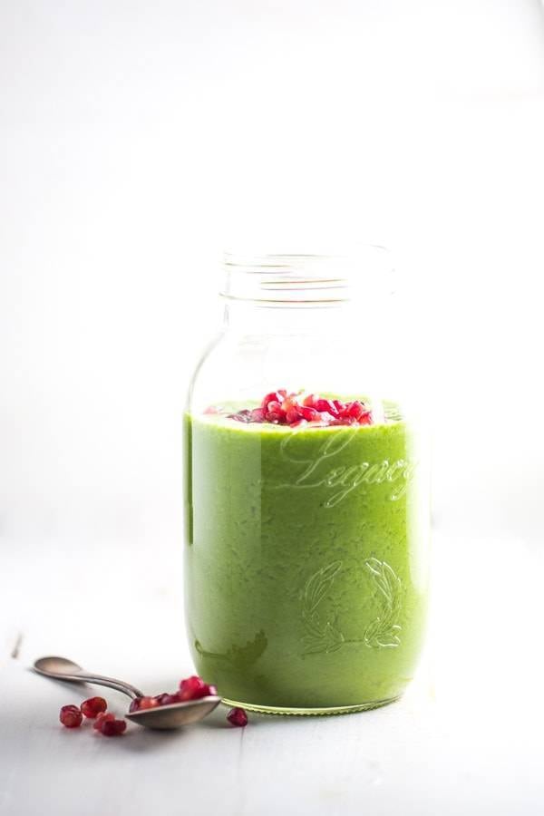 Green apple smoothie with pomegranate seeds.